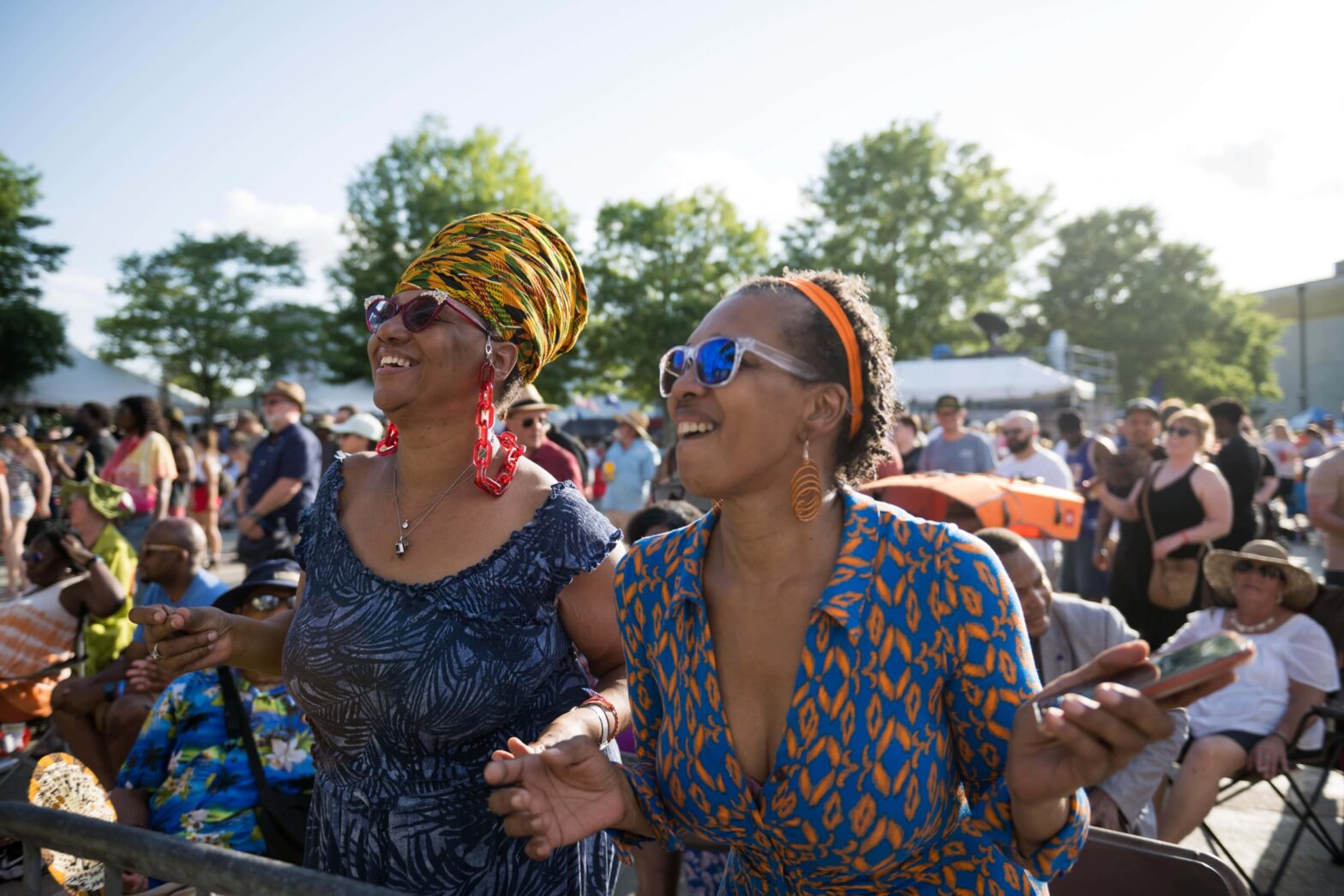 Two women of color in sunglasses enjoying the festival